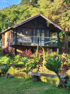 a house with a pond in front of it at Pousada Vale Monte Azul in Santo Antônio do Pinhal