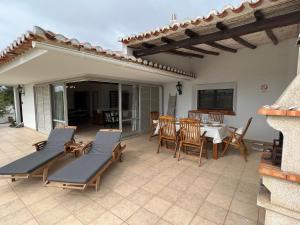 a patio with a table and chairs and a dining room at Vila Rosa - Private Swimming Pool With Sea View in Albufeira