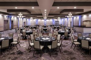 un salón de banquetes con mesas y sillas en una habitación en Pomeroy Hotel & Conference Centre, en Grande Prairie