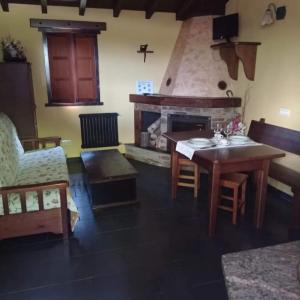 ein Wohnzimmer mit einem Tisch und einem Kamin in der Unterkunft Apartamento" El Carballo" in San Tirso de Abres