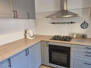 a kitchen with white cabinets and a stove top oven at Il Borgo Apartment in Pignone