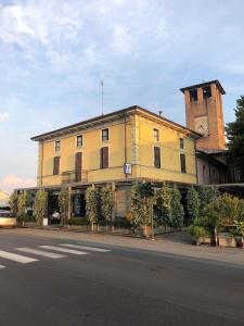 un edificio amarillo al lado de una calle en Locanda Da Romano, en Cadeo