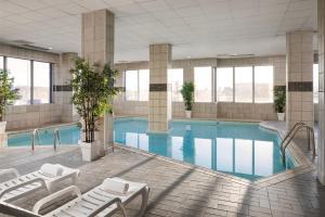 uma piscina num edifício com espreguiçadeiras ao lado em Pomeroy Hotel & Conference Centre em Grande Prairie
