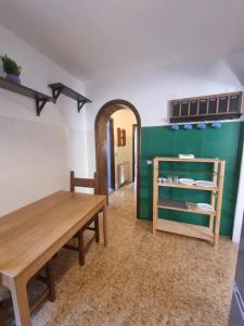 a dining room with a wooden table and a green wall at Il Borgo Apartment in Pignone