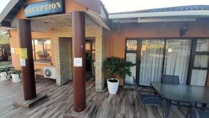 een restaurant met een tafel en stoelen op een terras bij Umqhele BnB in Richards Bay