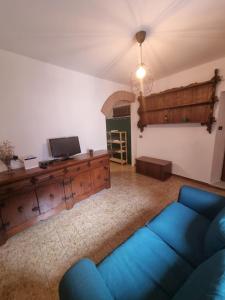 a living room with a blue couch and a tv at Il Borgo Apartment in Pignone