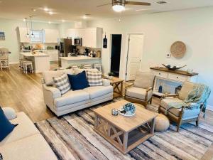 a living room with couches and chairs and a kitchen at Let's get Beachy! in Bolivar Peninsula