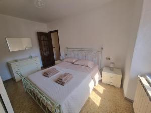 a bedroom with a white bed with two towels on it at Il Borgo Apartment in Pignone