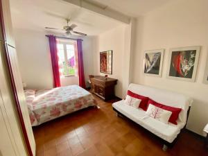 um quarto com uma cama, um sofá e uma janela em [Portofino] Appartamento in Villa vista mare em Lavagna