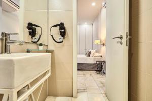 a bathroom with a sink and a bed in a room at Hello Alicante Apartamentos in Alicante