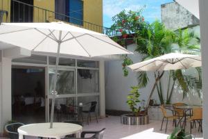 a patio with tables and chairs and umbrellas at Happy Day Pucallpa in Pucallpa