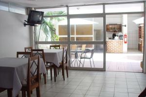 Happy Day Pucallpa في بوكالبا: غرفة طعام مع طاولة وكراسي وتلفزيون