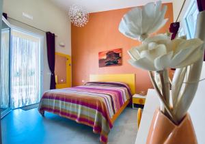 a bedroom with a bed and a flower in a vase at B&B L'EDEN DI CAPO BIANCO in Montallegro