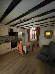 a living room with a table and a kitchen at Apartments Mora Cantada in Piran