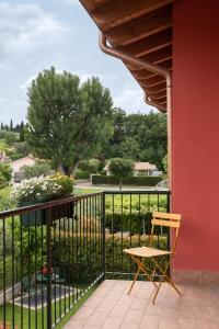 une chaise sur un balcon avec vue sur un parc dans l'établissement Bardolino Suite, à Bardolino