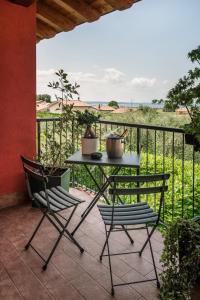 - une table et deux chaises sur une terrasse avec une clôture dans l'établissement Bardolino Suite, à Bardolino