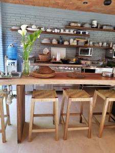 una cucina con tavolo in legno con sgabelli e tavolo con vaso di Hotel Bendita Luna a Mazunte