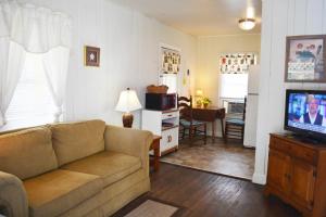 uma sala de estar com um sofá e uma televisão em Sunshine Cozy Cottage em Clearwater Beach