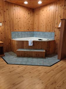 a bathroom with a bath tub in a wooden wall at Holiday Acres Resort in Rhinelander