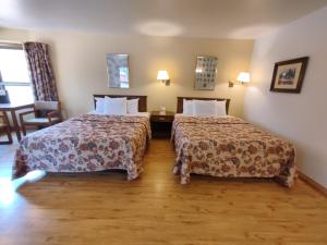a hotel room with two beds and a chair at Holiday Acres Resort in Rhinelander