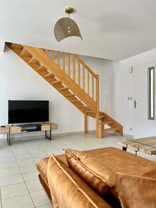 a living room with a staircase and a television at Villa La caroline 2 in Montpellier
