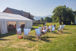 un groupe de personnes assises sur des chaises dans un champ dans l'établissement GPtents Camping - Spielberg, à Spielberg