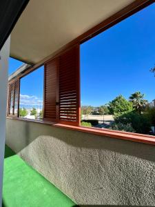 a balcony with a large window with a green floor at Villa La caroline 2 in Montpellier