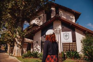 a woman wearing a hat standing in front of a building at Hotel Petrópolis in Nova Petrópolis