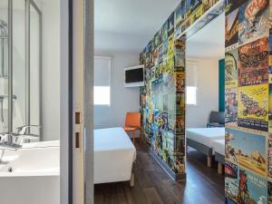 una camera con letto, lavandino e specchio di hotelF1 Paris Porte de Châtillon a Parigi