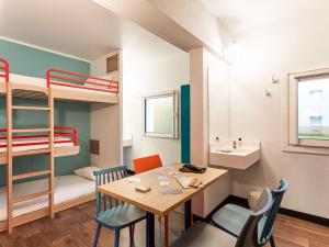 パリにあるホテルF1 パリ ポルト ドゥ シャティヨンのテーブルと二段ベッドが備わる小さな客室です。