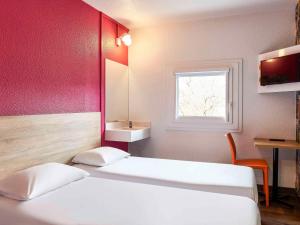 Habitación con 2 camas, lavabo y ventana en hotelF1 Paris Porte de Châtillon en París