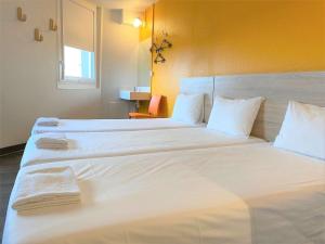 a bedroom with two beds with white sheets and a window at hotelF1 Paris Porte de Châtillon in Paris