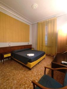 a bedroom with a bed and a desk and a chair at HOTEL MILAZZO in Rome