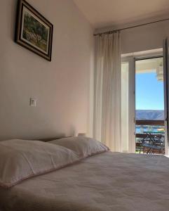 1 dormitorio con cama y ventana con vistas en Apartments and rooms Iva, en Pag