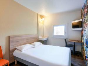 a bedroom with a white bed and a window at hotelF1 Paris Porte de Châtillon in Paris