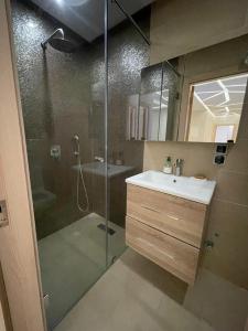馬拉喀什的住宿－Appartement A Ne Pas Rater A Marrakech，带淋浴、盥洗盆和镜子的浴室