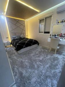 馬拉喀什的住宿－Appartement A Ne Pas Rater A Marrakech，一间卧室配有一张黑色的床和一张书桌