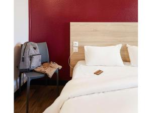 a bedroom with two beds and a backpack on a chair at hotelF1 Paris Porte de Châtillon in Paris