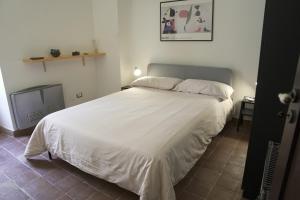 a bedroom with a large bed with white sheets at Casa delle Macine in Caltanissetta