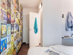 a room with a bed and a wall with posters at hotelF1 Paris Porte de Châtillon in Paris