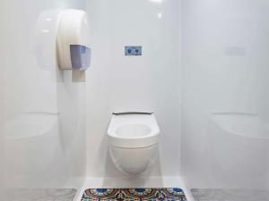 a white bathroom with a toilet and a phone at hotelF1 Paris Porte de Châtillon in Paris