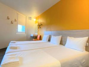 a bedroom with two beds with white pillows at hotelF1 Paris Porte de Châtillon in Paris
