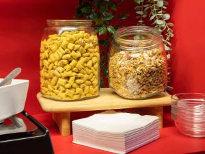 two jars filled with nuts on a wooden shelf at hotelF1 Paris Porte de Châtillon in Paris