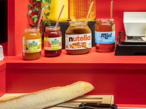 a shelf with three jars of mustard and a loaf of bread at hotelF1 Paris Porte de Châtillon in Paris