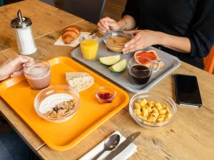 a person sitting at a table with a tray of food at hotelF1 Paris Porte de Châtillon in Paris