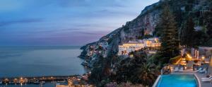 a view of the amalfi coast at night at Anantara Convento di Amalfi Grand Hotel in Amalfi