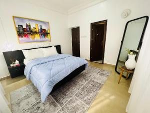 una camera con un letto e un grande specchio di House Ire ad Abuja