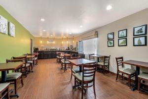 a restaurant with tables and chairs and a kitchen at Sleep Inn in Naperville