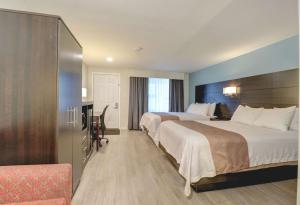 a hotel room with two beds and a desk at Quality Inn & Suites in Lincoln