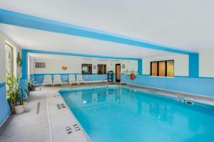 a large swimming pool in a house with blue walls at Comfort Inn in Huntingdon